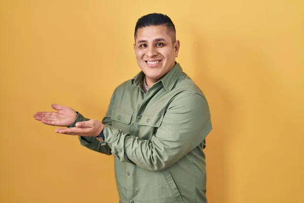Hispanic Young Man Standing Yellow Background Pointing Aside Hands Open — Stock fotografie