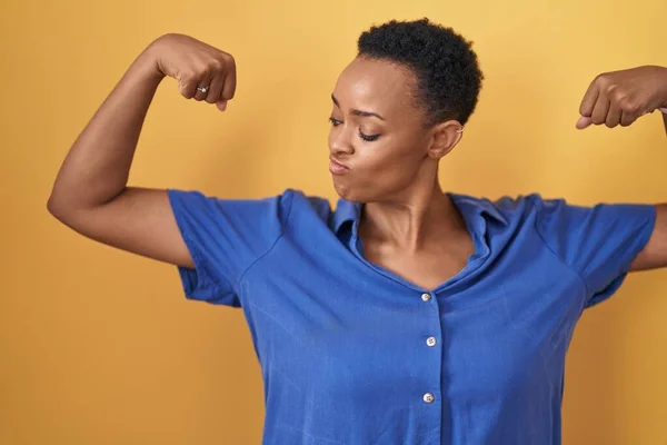 African American Woman Standing Yellow Background Showing Arms Muscles Smiling — Stok fotoğraf