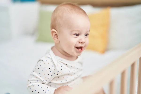 可爱的高加索婴儿笑着自信地坐在床上 坐在卧室里 — 图库照片