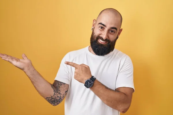 Young Hispanic Man Beard Tattoos Standing Yellow Background Amazed Smiling —  Fotos de Stock