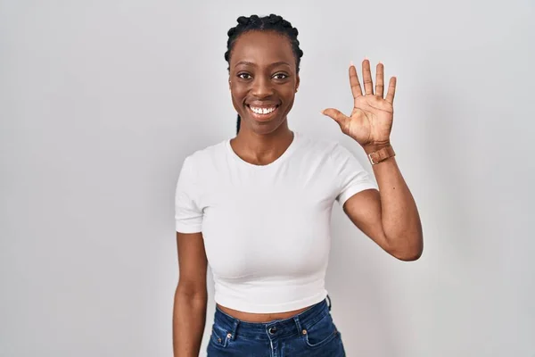 Beautiful black woman standing over isolated background showing and pointing up with fingers number five while smiling confident and happy.