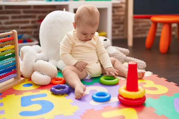 可爱的高加索婴儿在幼儿园的地板上玩圈圈玩具 — 图库照片