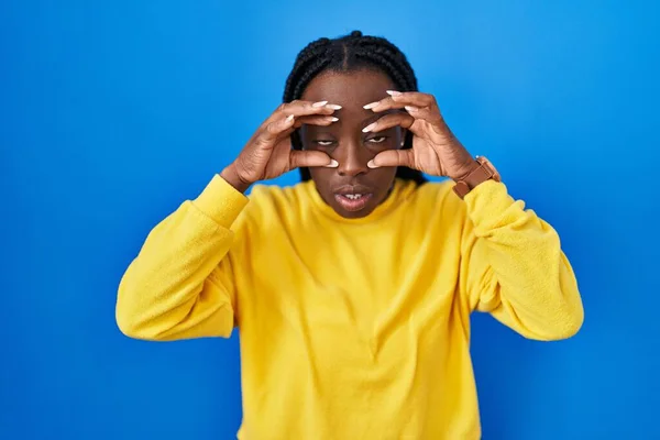 Beautiful Black Woman Standing Blue Background Trying Open Eyes Fingers — Fotografia de Stock