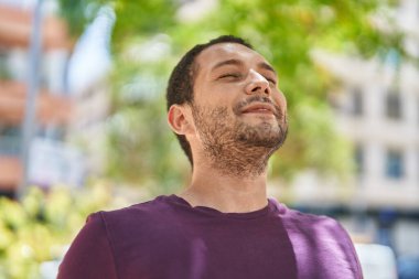 Young man smiling confident breathing at park