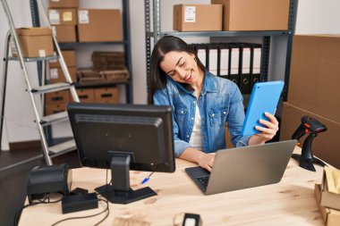 Young beautiful hispanic woman ecommerce business worker working at office