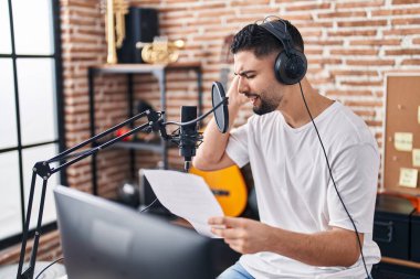 Genç Arap sanatçı müzik stüdyosunda şarkı söylüyor.