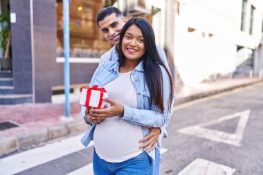 Genç Latin çift sokakta hediye bekliyor.