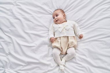 Sevimli bebek yatakta kendinden emin bir şekilde yatıyor.