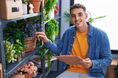 Çiçekçi dükkanındaki belgelerde kendinden emin gülümseyen İspanyol bir çiçekçi.