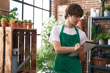 Çiçekçide kendine güvenen genç sarışın bir çiçekçi.