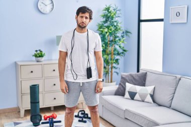 Handsome latin man wearing sportswear at home depressed and worry for distress, crying angry and afraid. sad expression. 