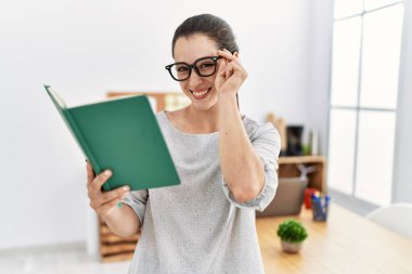 Ofiste kendine güvenen genç İspanyol kadın gülümsüyor.