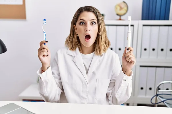 Young Hispanic Dentist Woman Holding Electric Toothbrush Teethbrush Clinic Afraid — ストック写真