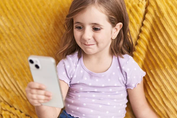 Roztomilý Hispánský Dívka Pomocí Smartphone Sedí Pohovce Doma — Stock fotografie