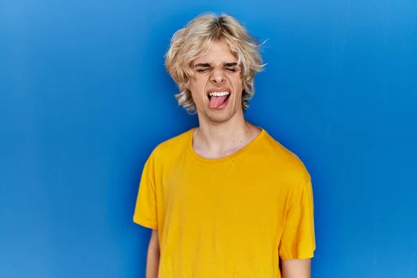 Young Modern Man Standing Blue Background Sticking Tongue Out Happy — Stockfoto