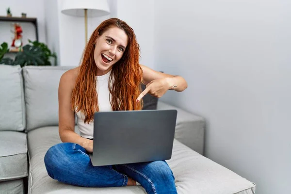 Jonge Roodharige Vrouw Met Laptop Thuis Glimlachend Vrolijk Wijzend Met — Stockfoto
