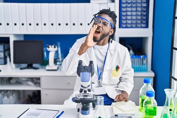 科学研究所で働いてるアフリカ人のドレッドロックが腕を広げて混乱してる — ストック写真