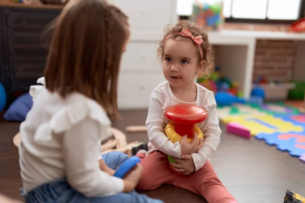 二人の小さな女の子プレイともにフロアに座って幼稚園 — ストック写真