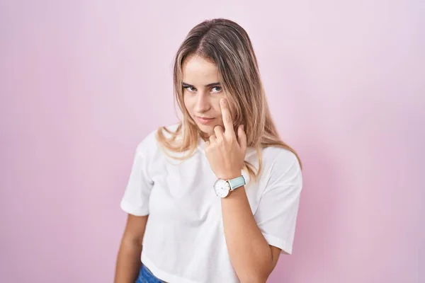 Young Blonde Woman Standing Pink Background Pointing Eye Watching You — Stockfoto