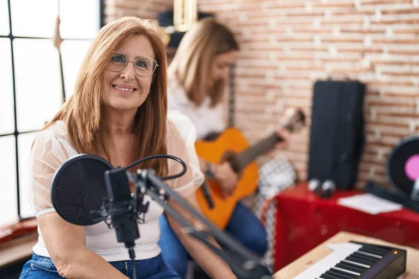 Mother and daughter playing classical guitar make selfie by the smartphone at music studio
