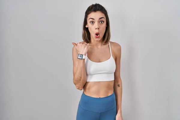 Hispanic Woman Wearing Sportswear Isolated Background Surprised Pointing Hand Finger — Stok fotoğraf
