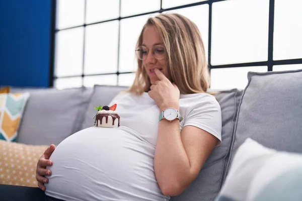 Young Pregnant Woman Looking Cake Touching Belly Home — Stock Photo, Image