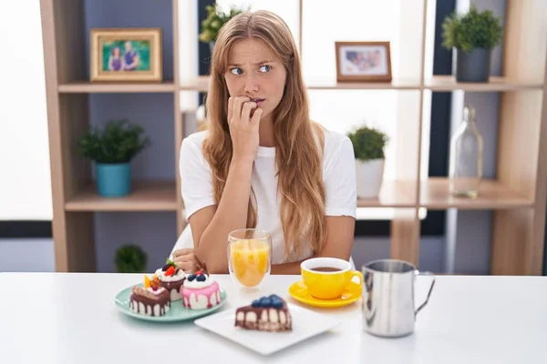 Ung Kaukasisk Kvinna Äter Bakverk Till Frukost Ser Stressad Och — Stockfoto