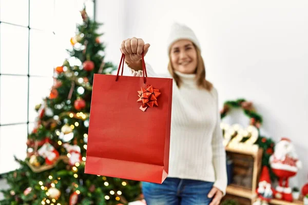 中年妇女笑着自信地拿着圣诞礼物袋回家 — 图库照片