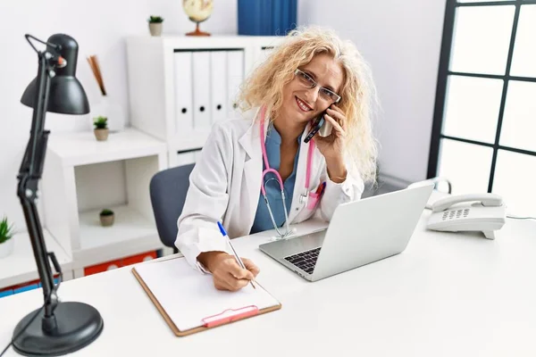 Středního Věku Blondýny Žena Nosí Lékařskou Uniformu Mluví Smartphone Klinice — Stock fotografie