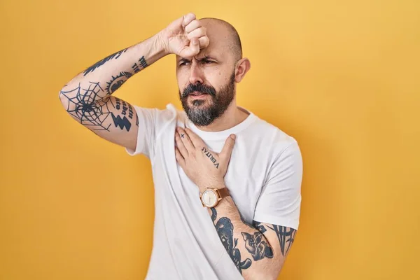 Young Hispanic Man Tattoos Standing Yellow Background Touching Forehead Illness — Stockfoto