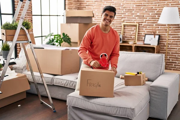 Young Hispanic Man Smiling Confident Packing Cardboard Box New Home — Stock Photo, Image