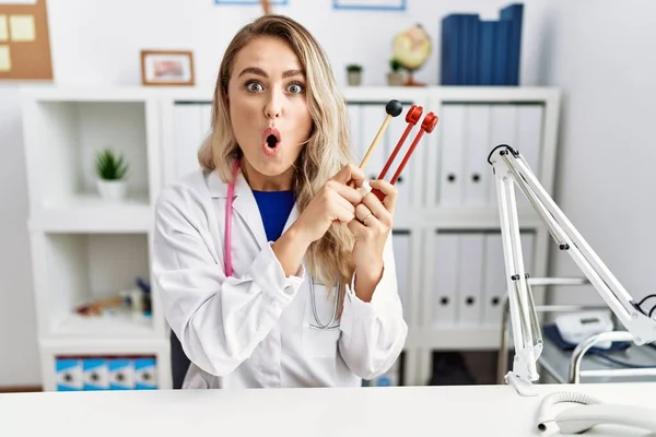 Young Beautiful Doctor Woman Holding Diapason Instrument Afraid Shocked Surprise — Stock Photo, Image