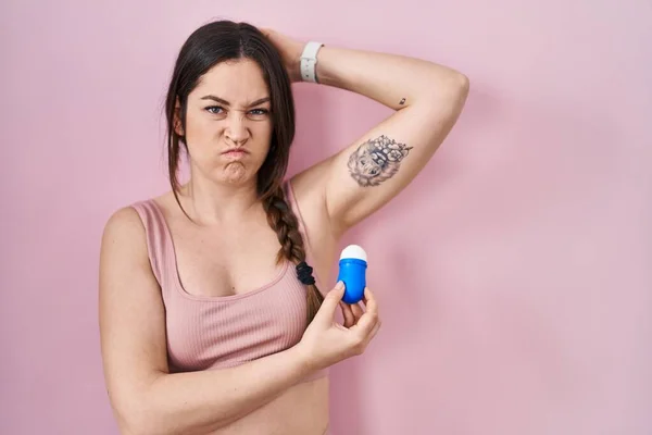 Young Brunette Woman Using Roll Deodorant Skeptic Nervous Frowning Upset —  Fotos de Stock