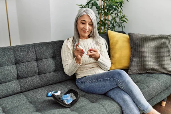 Middle Age Grey Haired Woman Smiling Confident Measuring Glucose Home — Stockfoto