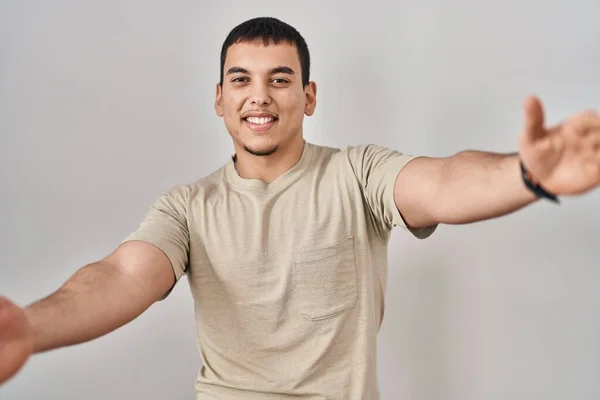 年轻的阿拉伯男子穿着休闲装 看着镜头 张开双臂拥抱 欢快的表达拥抱幸福 — 图库照片