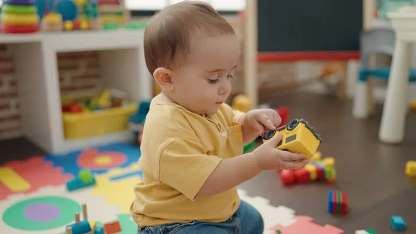Adorable Hispanic Baby Playing Car Toy Sitting Floor Kindergarten — 图库照片
