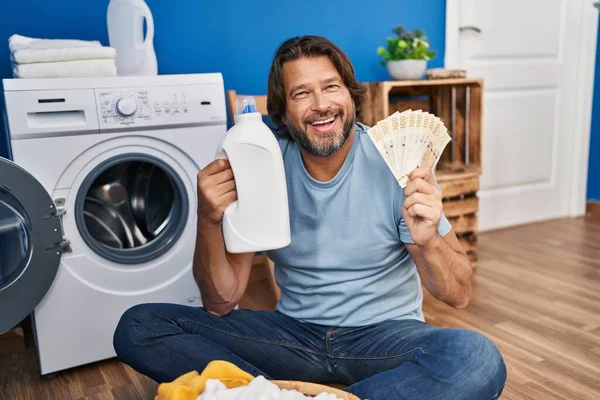 洗濯洗剤のお金を節約するハンサムな中年の男笑顔と大声で笑いますので面白いクレイジー冗談 — ストック写真