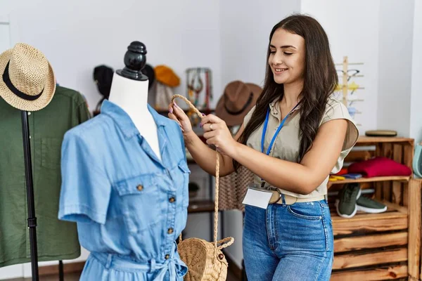 年轻的高加索女人带着自信的笑容在服装店工作 — 图库照片