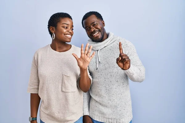 Jong Afrikaans Amerikaans Paar Staande Blauwe Achtergrond Samen Tonen Wijzen — Stockfoto