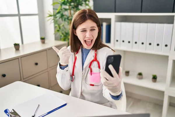 Young Doctor Woman Doing Video Call Smartphone Pointing Thumb Side — Fotografia de Stock