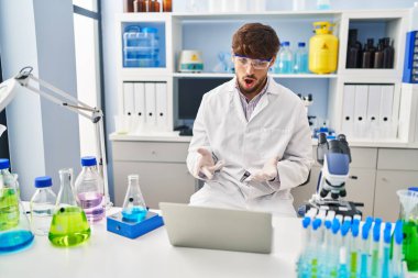 Young arab man scientist having video call working at laboratory