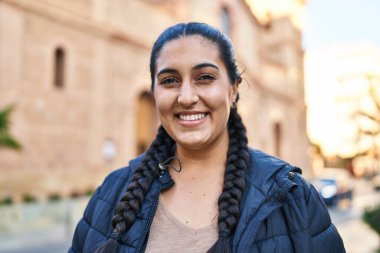 Sokakta kendine gülen genç İspanyol kadın.