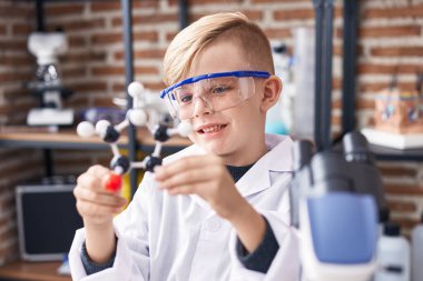 Sevimli çocuk gülümsemesi sınıfta molekül tutarken kendinden emin.