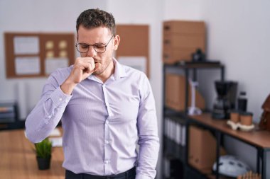 Ofisteki İspanyol genç adam kendini iyi hissetmiyor ve soğuk algınlığı veya bronşitin belirtisi olarak öksürüyor. sağlık hizmeti kavramı. 