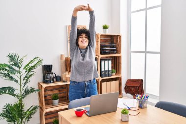 Young middle east woman business worker stretching arms at office