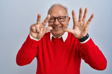 Senior man with grey hair standing over isolated background showing and pointing up with fingers number eight while smiling confident and happy. 