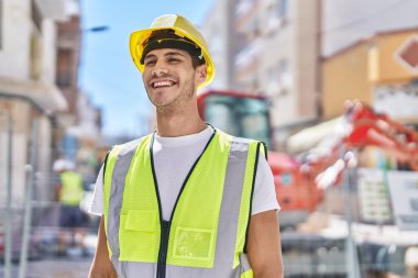 Genç İspanyol mimar parkta kendine güvenerek gülümsüyor.