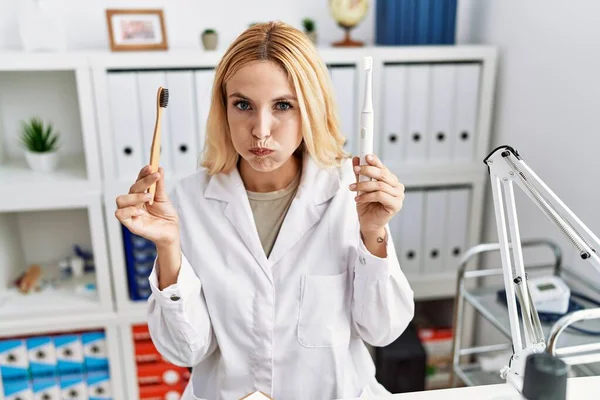 Vacker Blond Tandläkare Kvinna Som Håller Elektrisk Tandborste Och Normal — Stockfoto