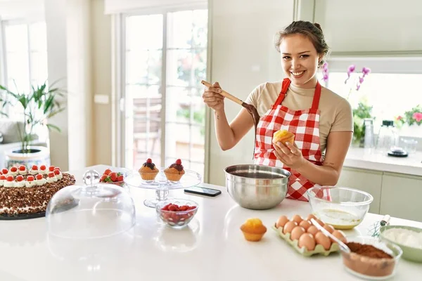 Young Beautiful Hispanic Woman Smiling Confident Putting Chocolate Muffin Kitchen — Stock Photo, Image