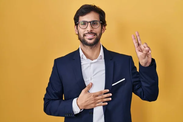 Handsome Latin Man Standing Yellow Background Smiling Swearing Hand Chest — Stockfoto
